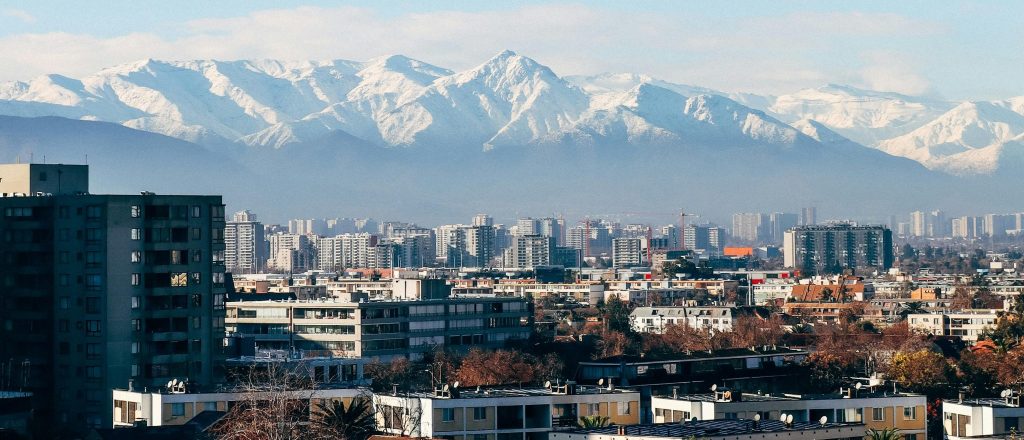 Vista panorámica de Santiago con la cordillera de los Andes al fondo, skyline moderno o barrio histórico de la ciudad.